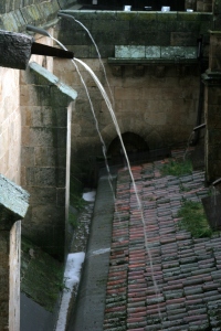 spouts on cathedral roof overflowing with water
